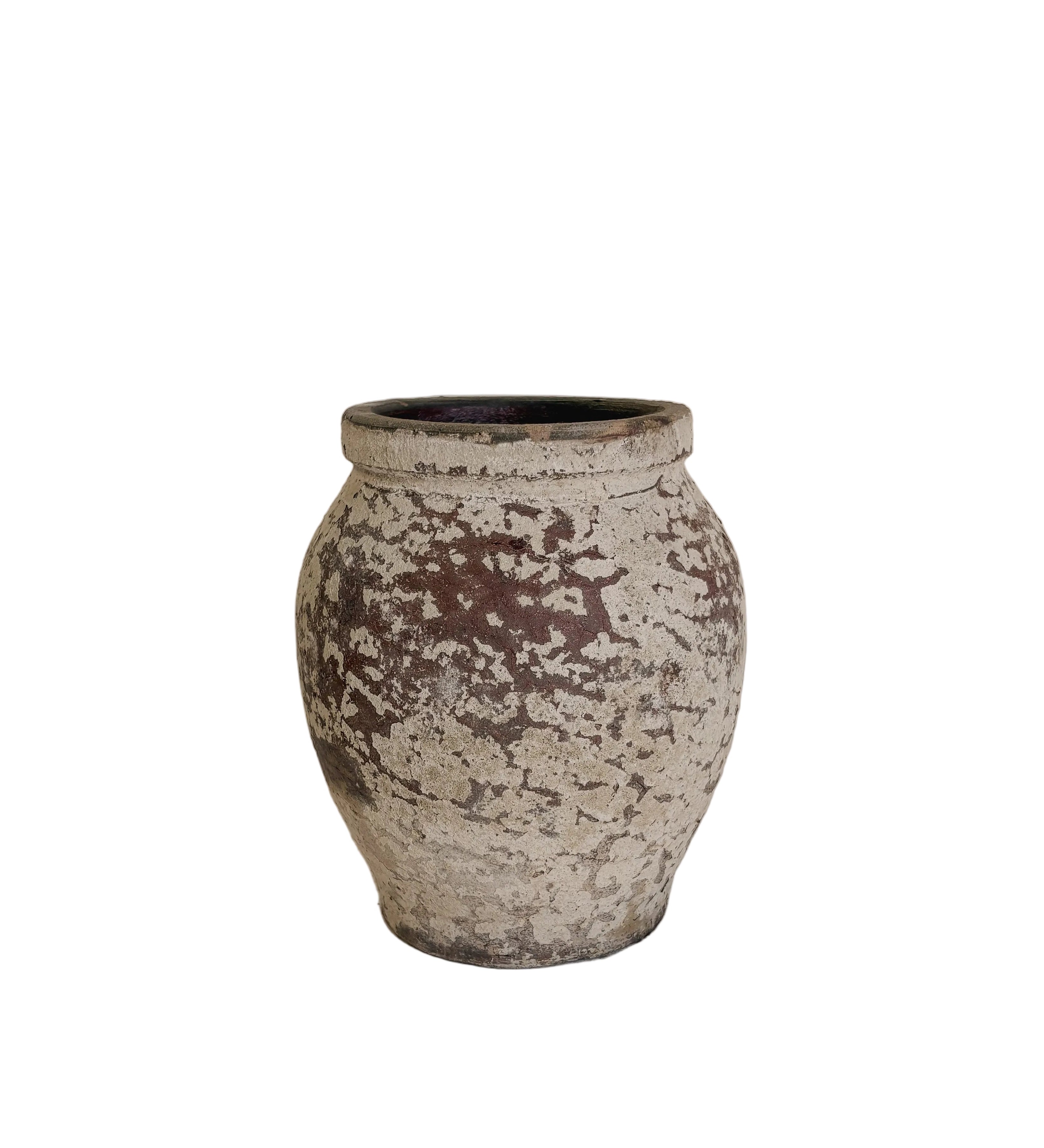 A small rustic ceramic pot with a distressed, mottled glaze in earthy brown and off-white, displayed on a white pedestal against a neutral beige wall.