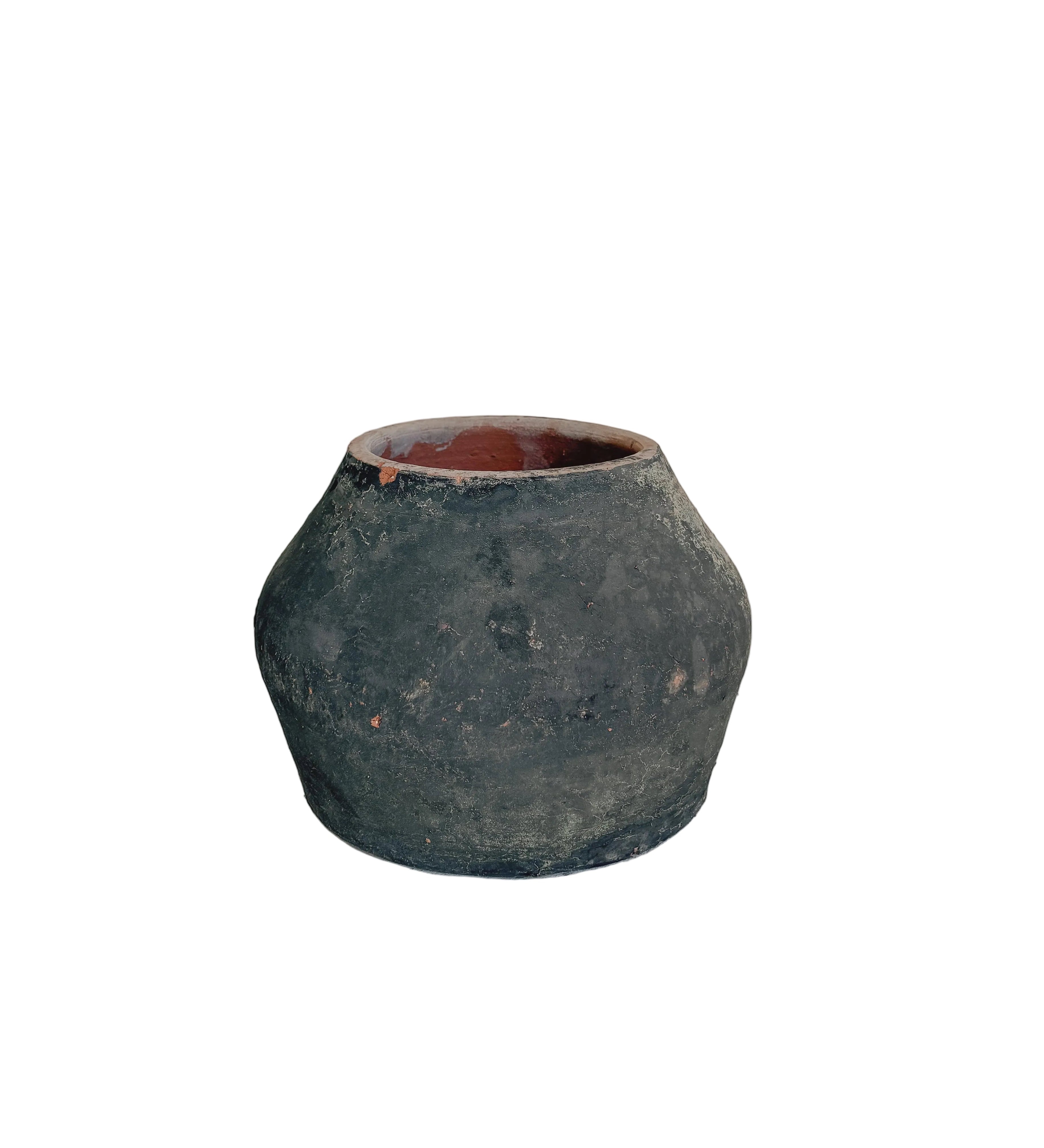 A small rustic dark green ceramic pot with a terracotta-colored interior, displayed on a light gray pedestal against a neutral beige background.
