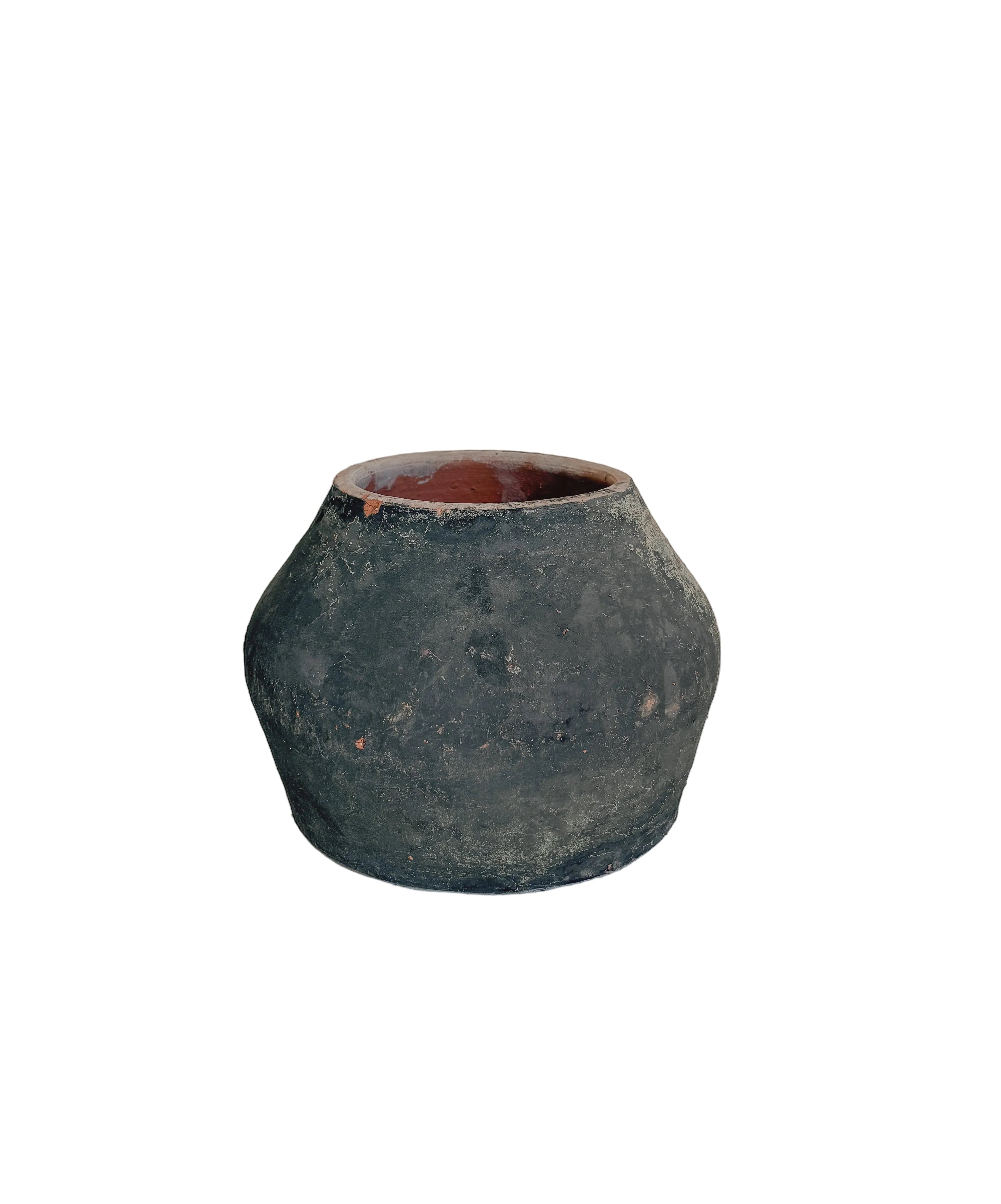 A small rustic dark green ceramic pot with a terracotta-colored interior, displayed on a light gray pedestal against a neutral beige background.